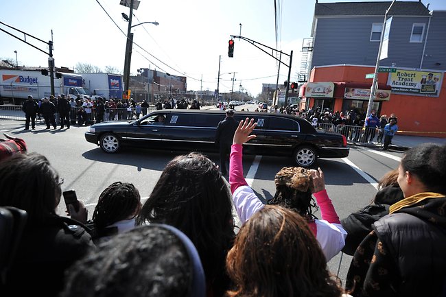 แฟนเพลงโบกมือให้รถลิมูซีนคันหนึ่งที่กำลังมุ่งหน้าไปยังโบสถ์นิว โฮป แบพติสต์ (ภาพ: AFP)